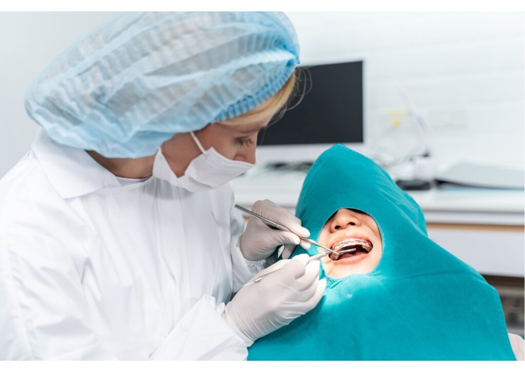 Orthodontist adjusting braces during a dental visit in a clinical setting.
