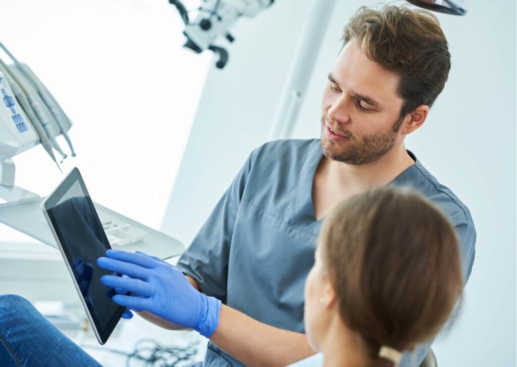 Orthodontist reviewing a treatment plan with a patient, explaining how braces can fix an overbite and improve overall dental alignment.