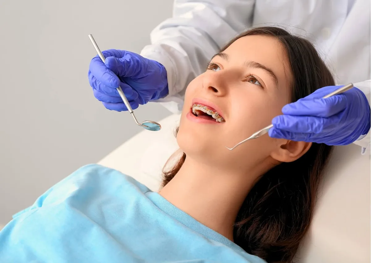 Orthodontic examination of a patient wearing braces for open bite correction.